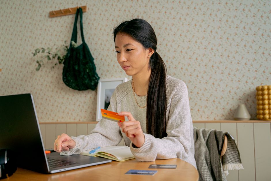 ノートパソコンとカードを手に、申し込みを決める様子