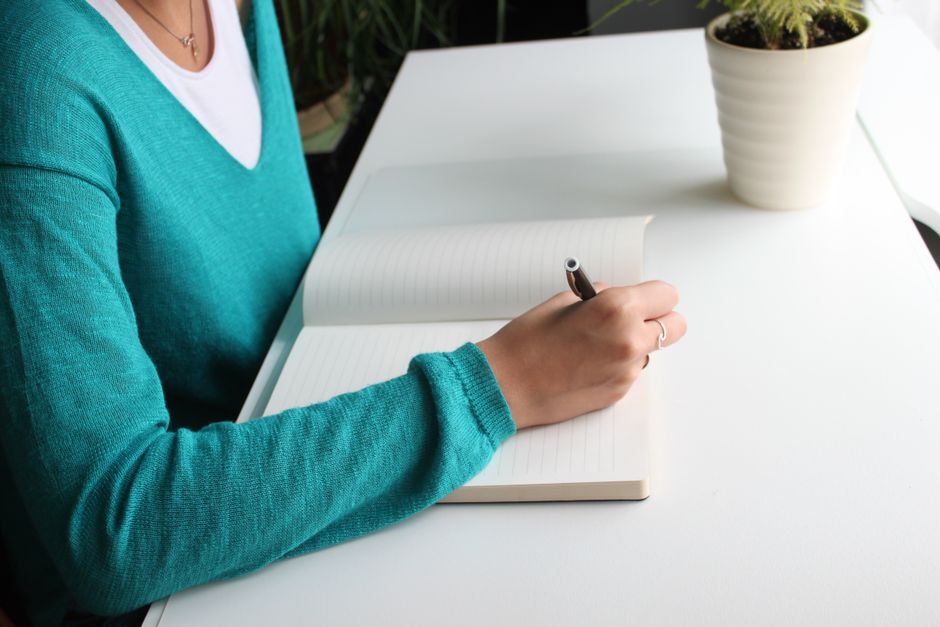 ノートに自分の業務を書き出して整理する様子